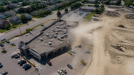 Commercial plaza with rooftop HVAC units beside a construction site